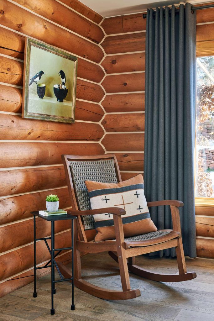 A log cabin corner with a rocking chair