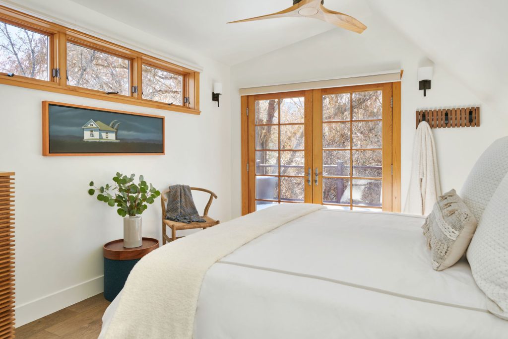 A white upscale bedroom with its own balcony