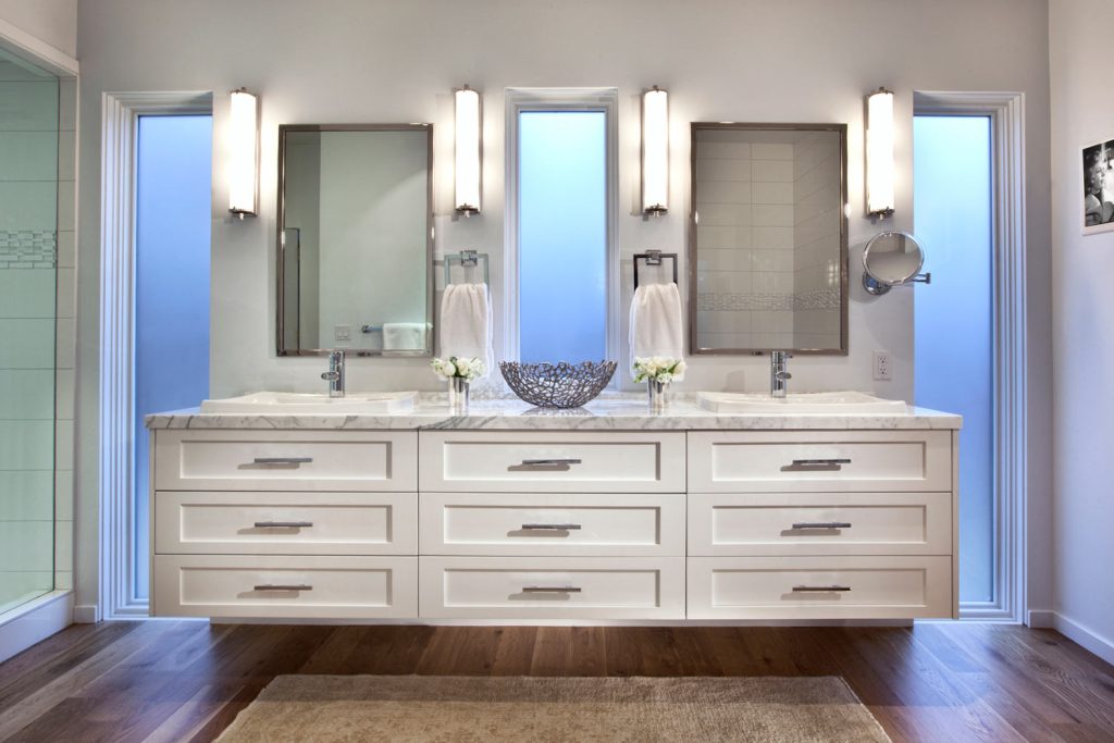 A luxury white bathroom with floating cabinets