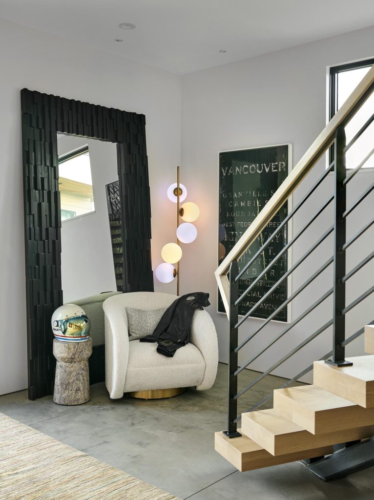 A stairway with an accent chair at the bottom of it