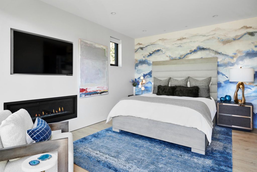 A luxury bedroom with a stunning accent wall and built-in fireplace