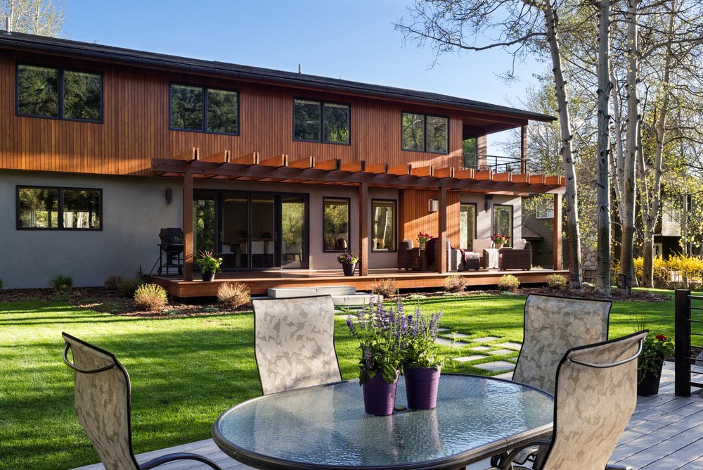 A beautiful backyard view of a custom home, back porch and patio