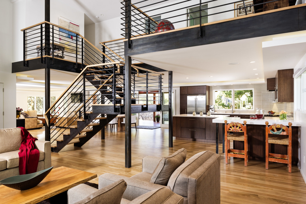 An open floor plan area containing the staircase, the kitchen, and two separate living room areas