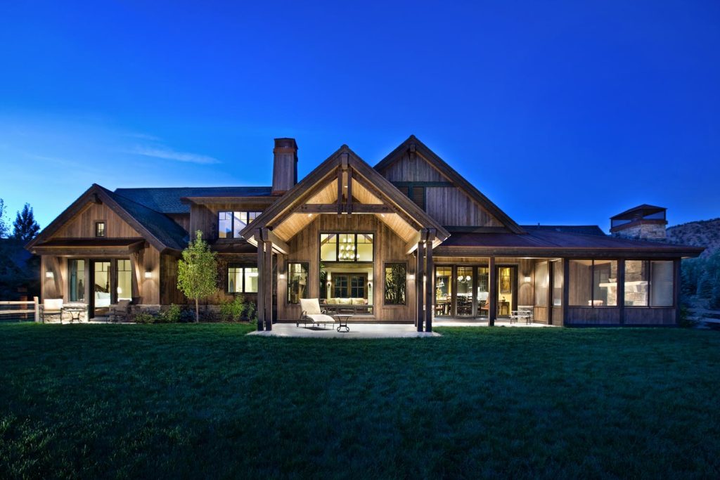 A backyard view of a custom luxury home with several back patios
