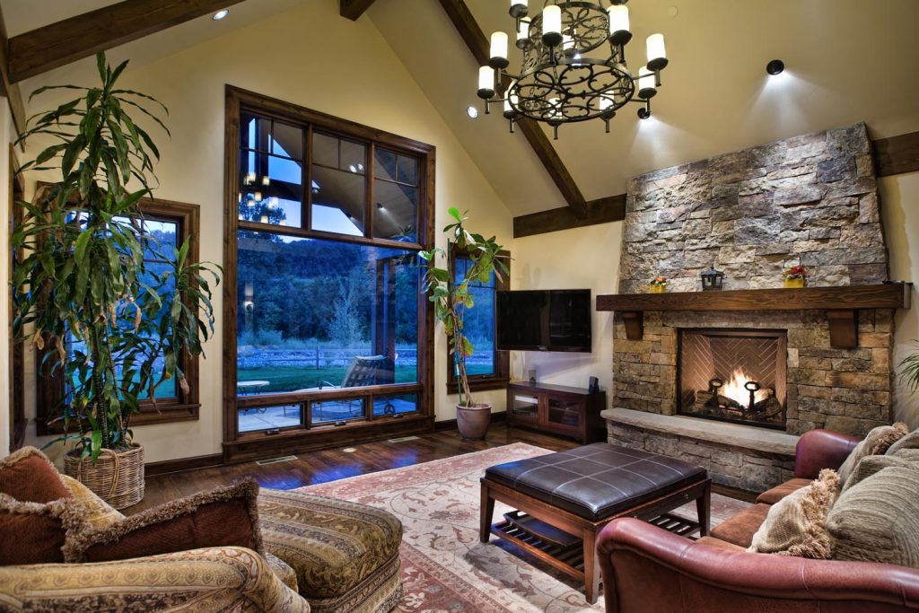 A rustic luxury living room with a statement fireplace and chandelier