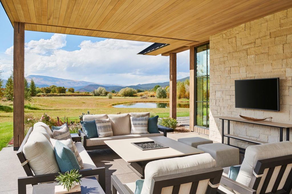 An outdoor living room with a television and fire pit