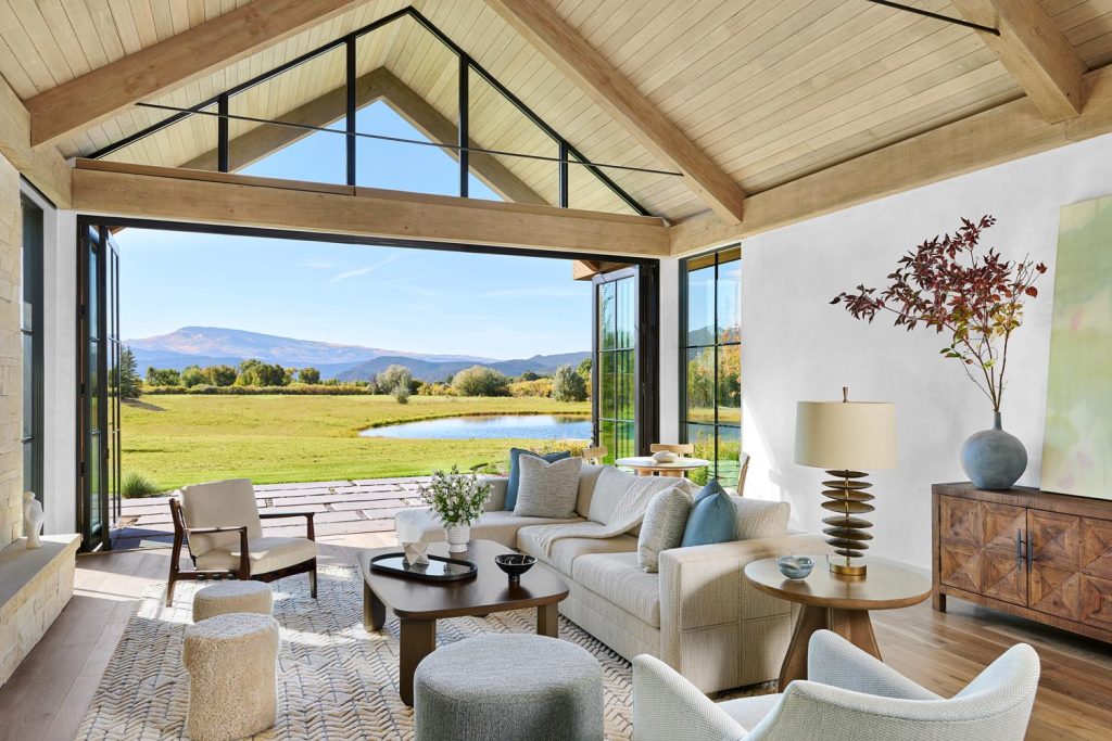 The glass walls of this living room open up to allow free passage between the interior and exterior entertaining rooms