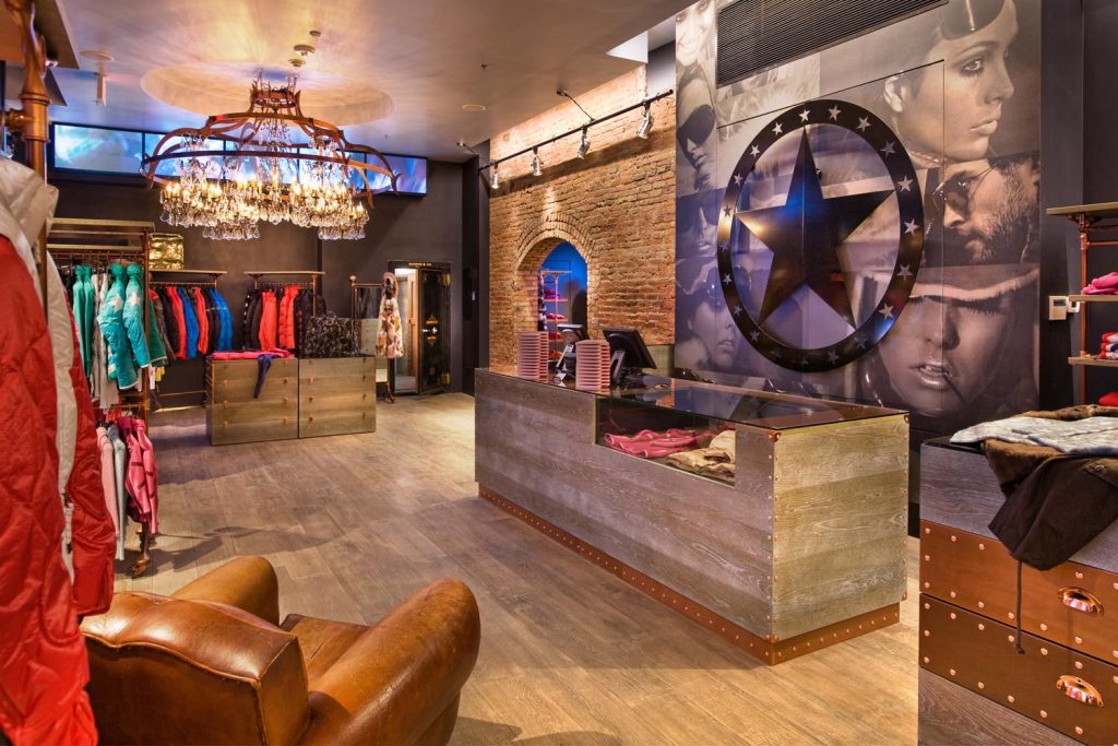 The interior of a boutique with an accent wall and a stunning chandelier