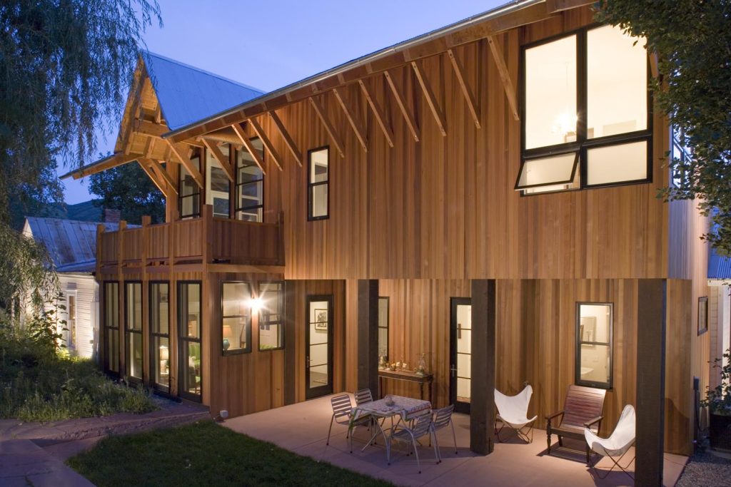 An outdoor view of a wooden luxury home with an outdoor patio