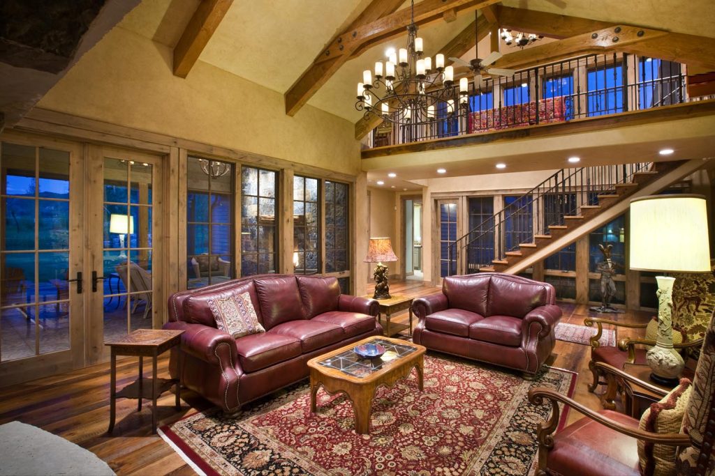 A luxury living room with a staircase leading to an interior balcony