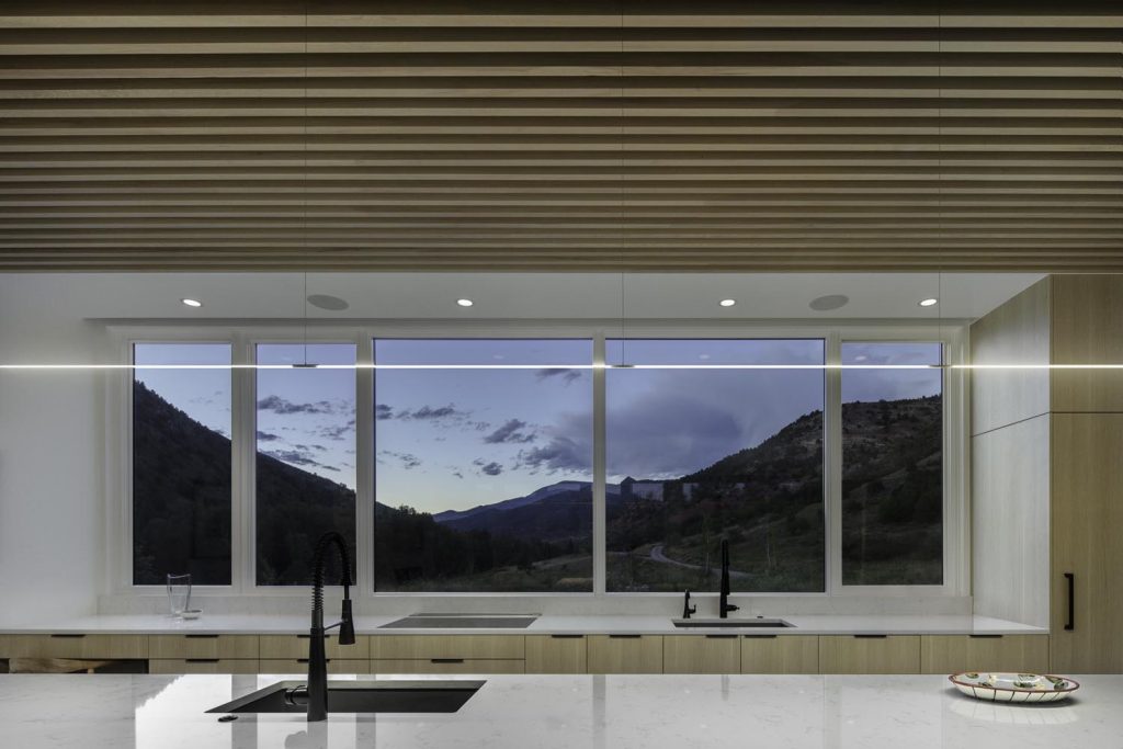 A kitchen with large windows overlooking the mountains