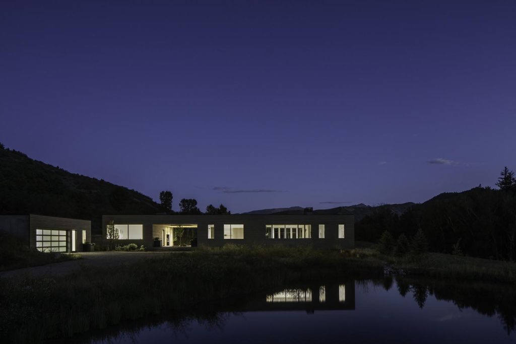 A waterfront view of a home at night