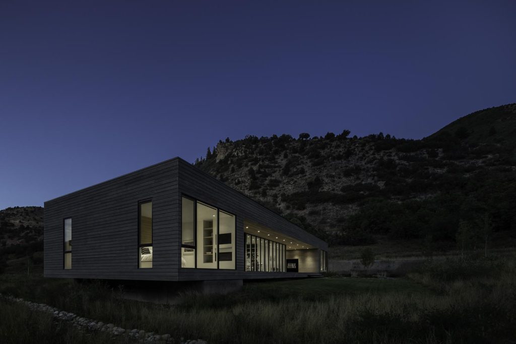 A hillside view of a luxury home at night