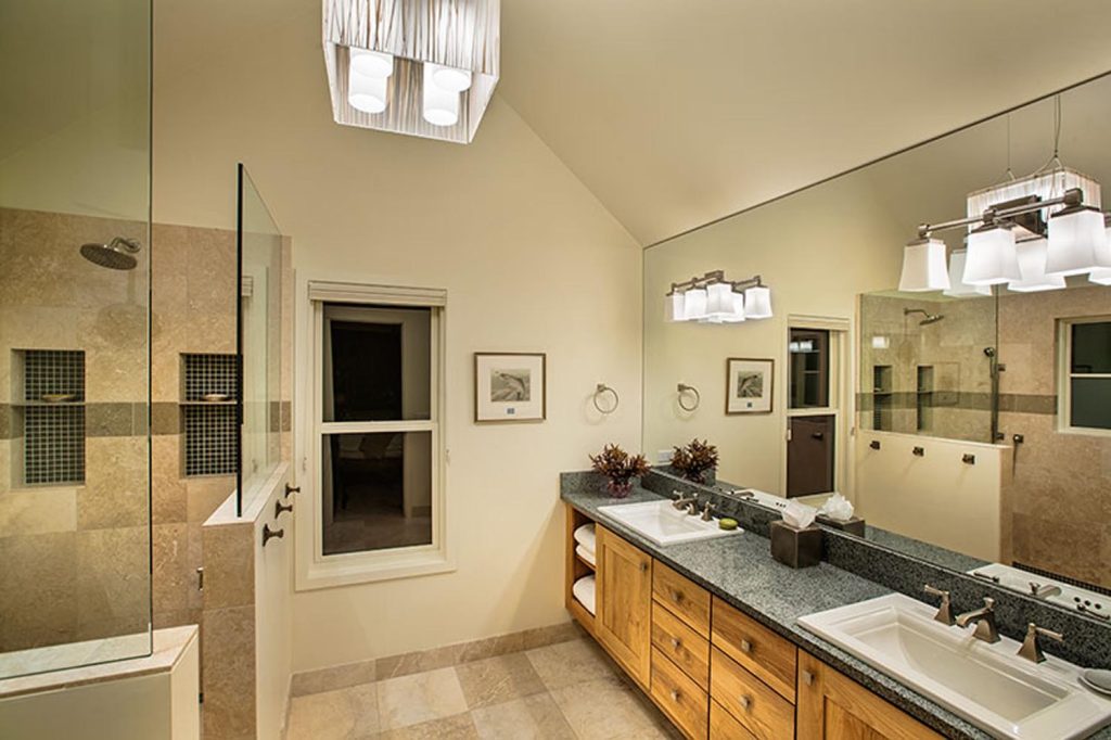 A cream bathroom with a walk-in shower and double-sink vanity