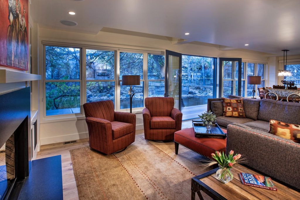 A living room with luxurious windows overlooking the river outside