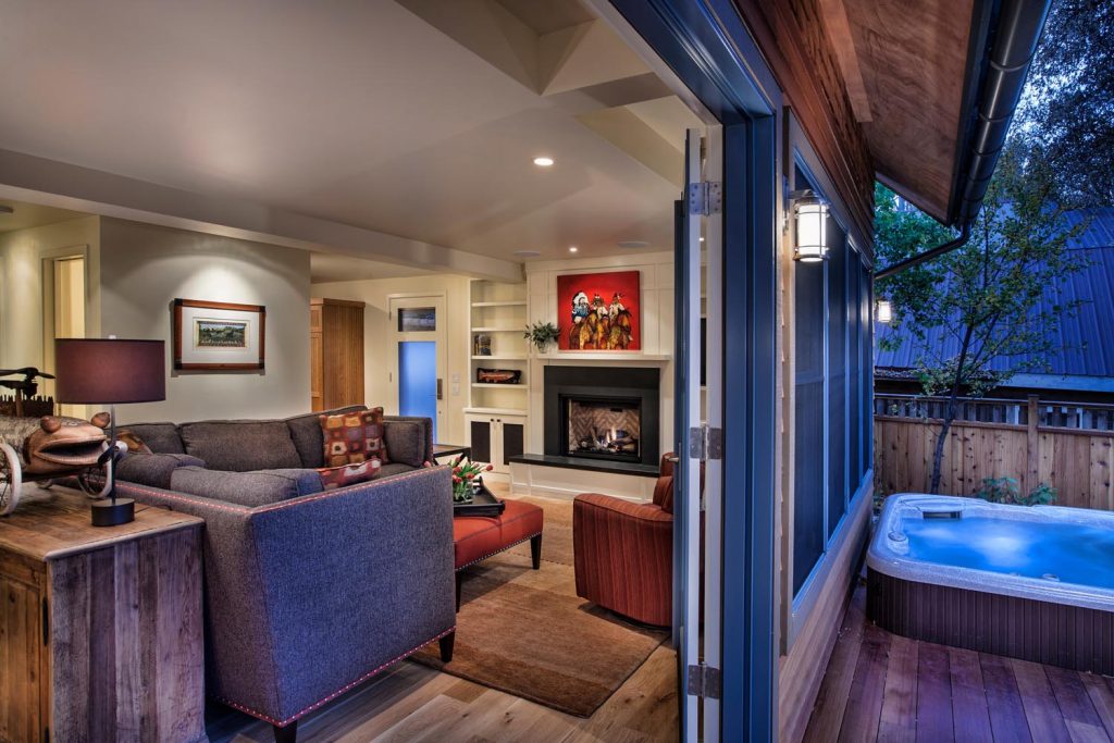 A log cabin back porch and living room, made with warm wood and soft cream walls.