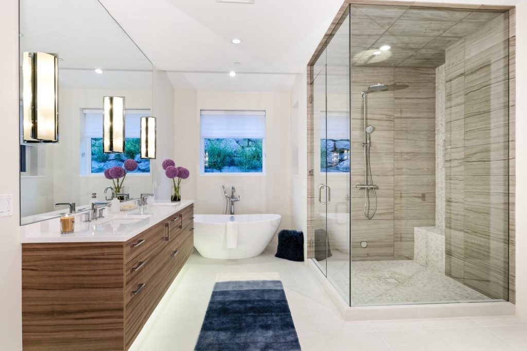 A master bathroom with a freestanding white tub and glass shower