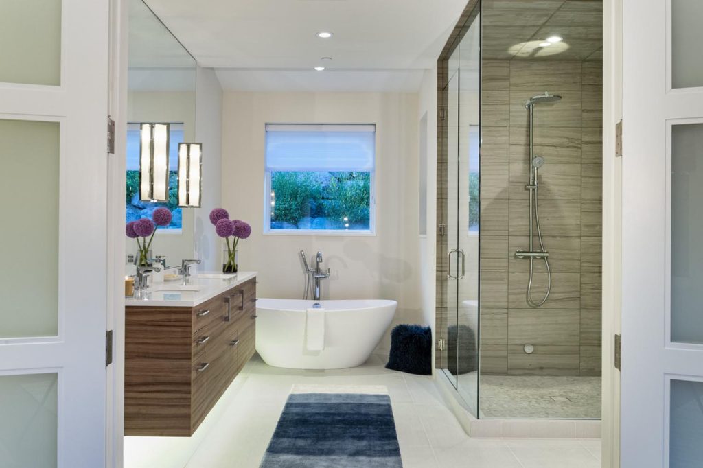 A master bathroom with a freestanding white tub and glass shower