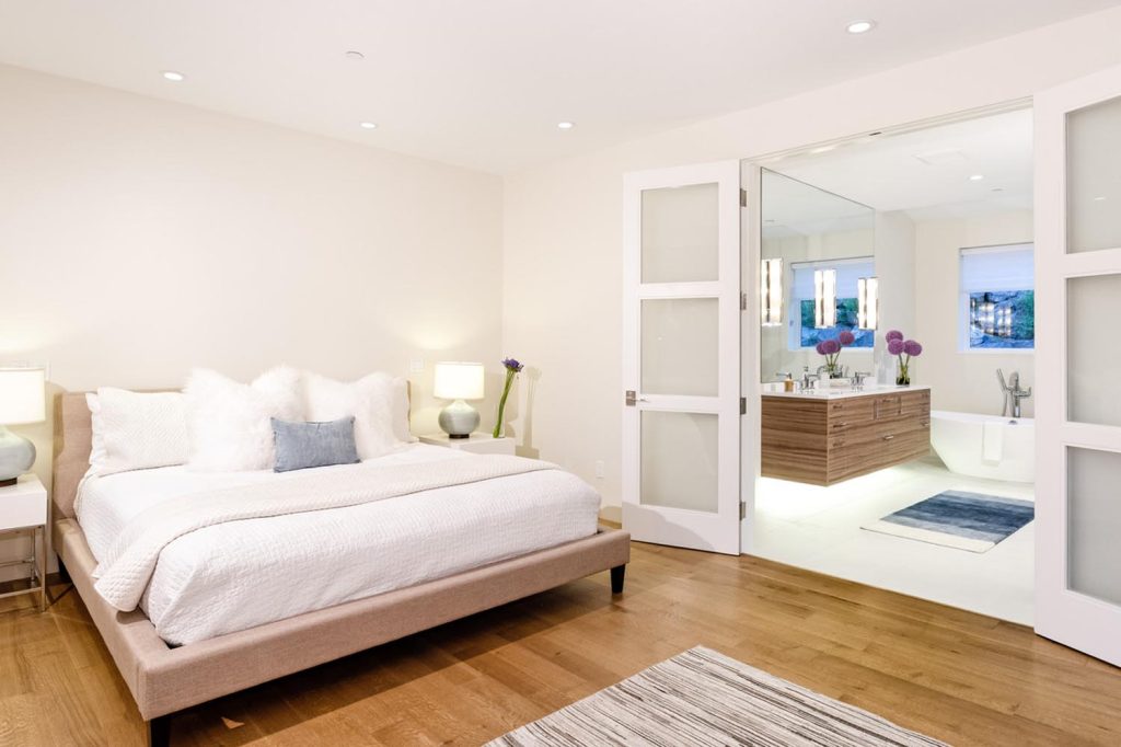 An upscale master bedroom and its master bathroom