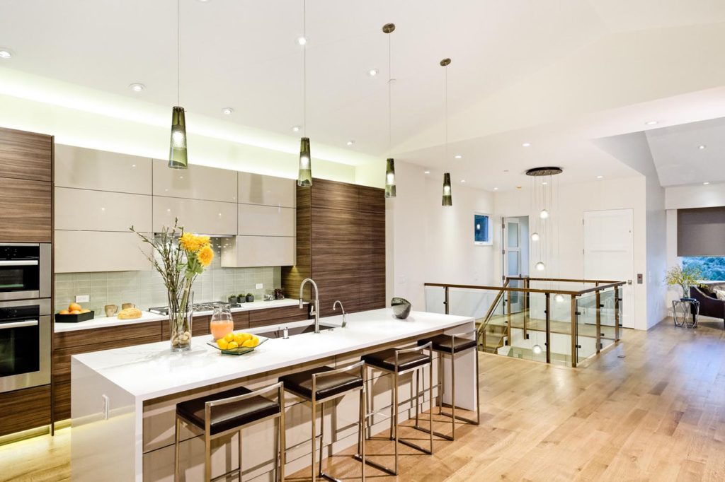 A luxury kitchen with an open floor plan and staircase