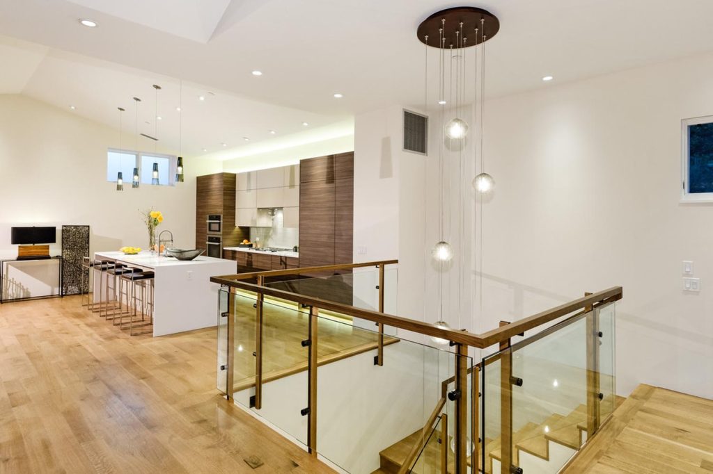 An upscale kitchen and chandelier over the staircase