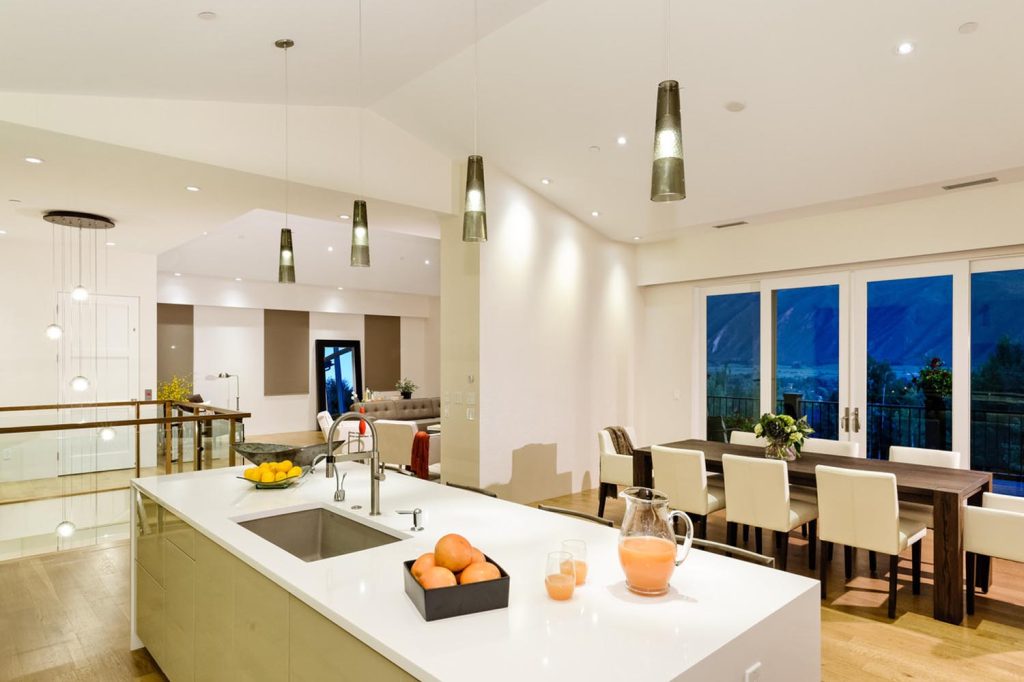 A white luxury kitchen and accompanying dining room