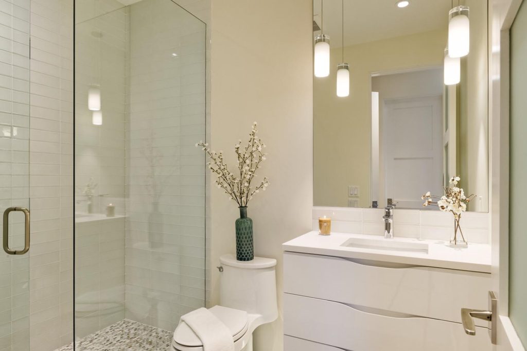 A white luxury bathroom with a glass shower