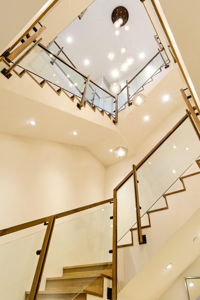 A luxury staircase with a glass banister