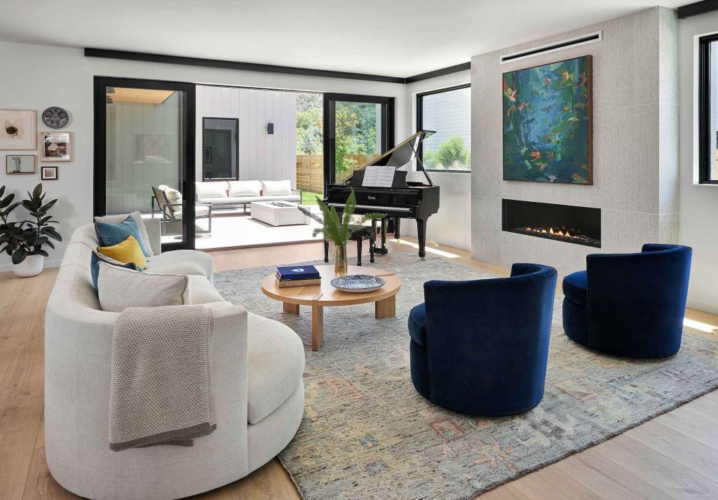 A living room featuring a fireplace, grand piano and luxurious couch